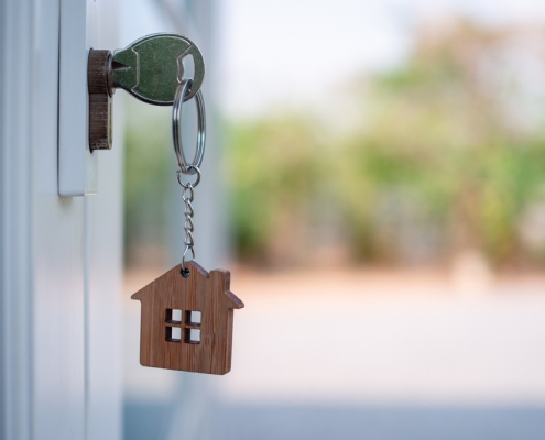 Key in an Exterior Door Lock With a Simple House Cutout Keychain